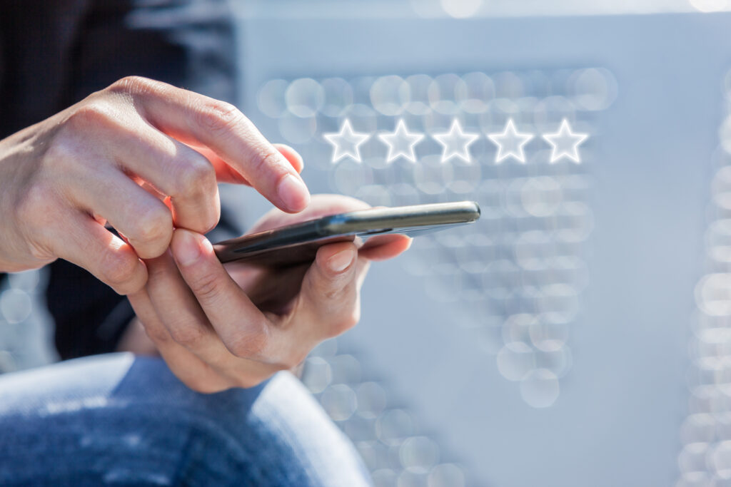 Customer Service Experience Performance Analysis. Close-up of Woman's Hand Holding a Smart Phone with Icon Five Star Symbol to Increase Rating of Company.